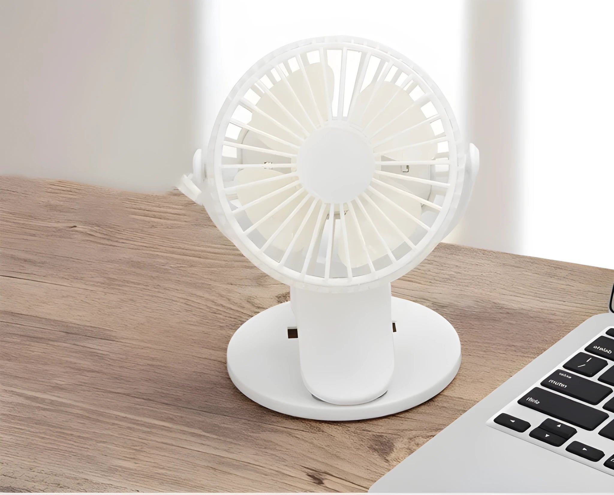 White USB rechargeable clip fan with plastic blades attached to a desk edge.