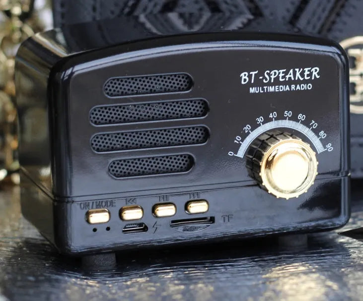 Compact vintage-style wood grain finish Bluetooth speaker on a wooden surface.