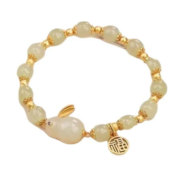Green jade women's bracelet with a sculpted hare charm, engraved Fu character, and lily detailing