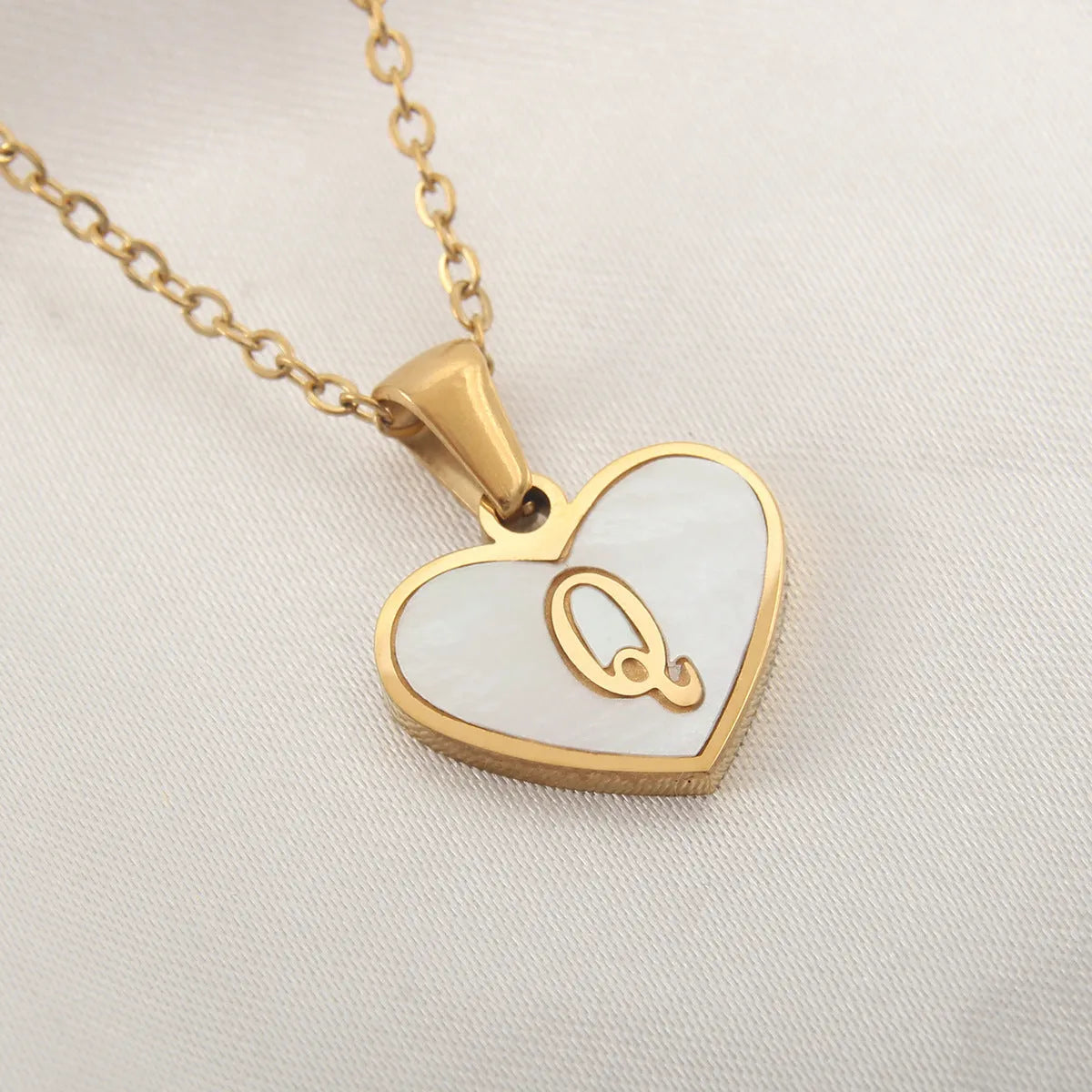 Gold plated heart-shaped necklace with white shell pendant on adjustable stainless steel chain