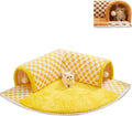 Brown plush plaid cat tunnel bed with central mat on a wooden floor.