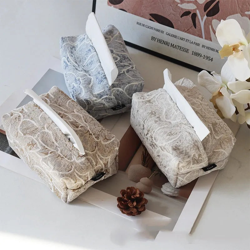Handmade beige rose patterned cotton fabric tissue box cover on a wooden table.