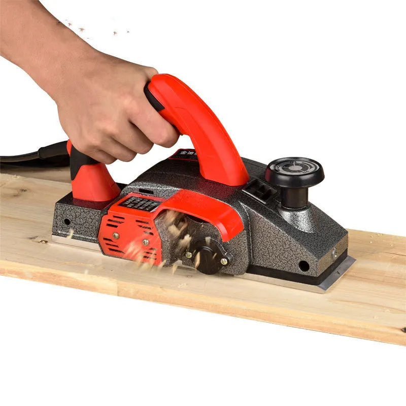Red desktop electric wood planer with aluminium housing showing 82mm cutting width