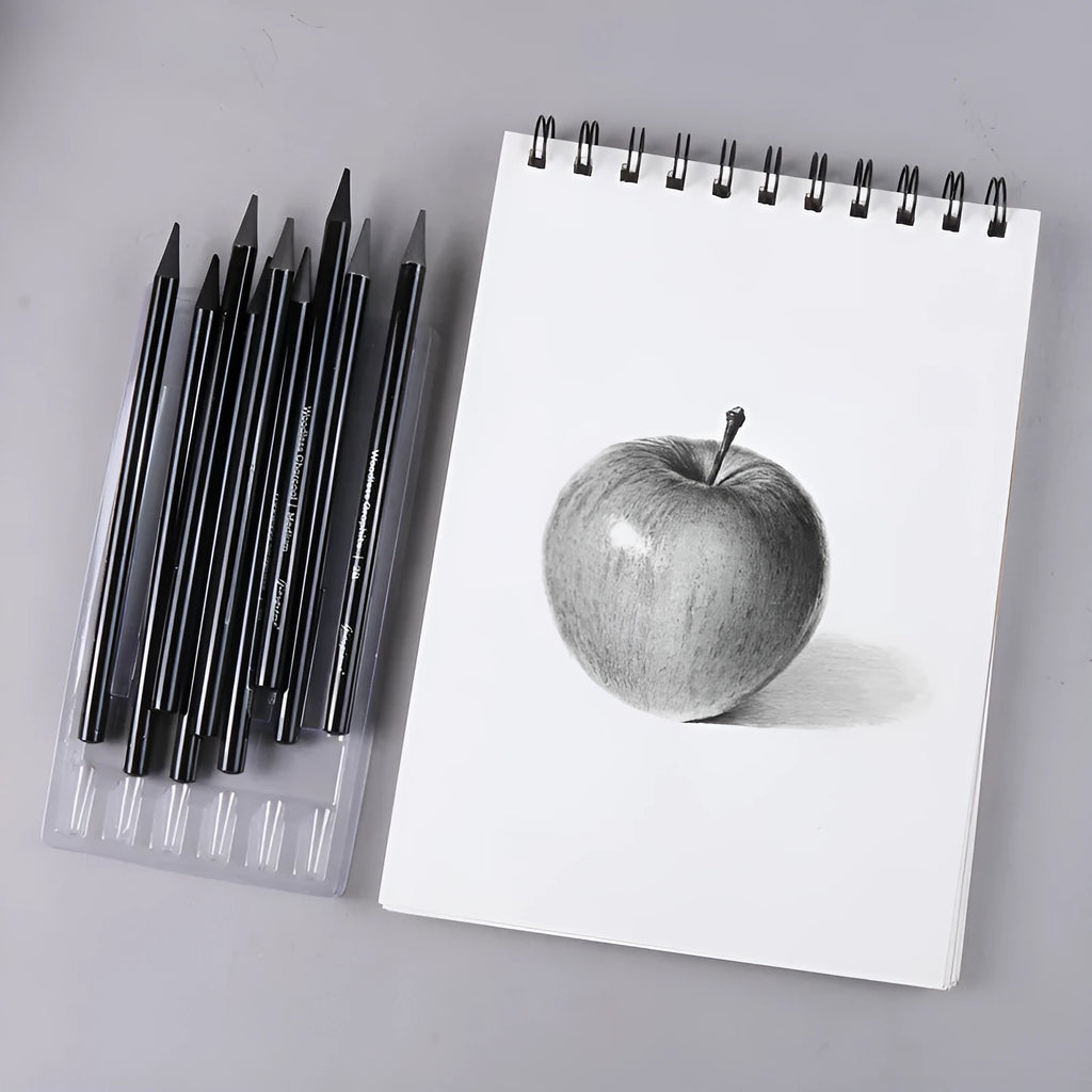 Set of nine wooden drawing pencils on a card, including graphite and carbonized pencils for sketching.