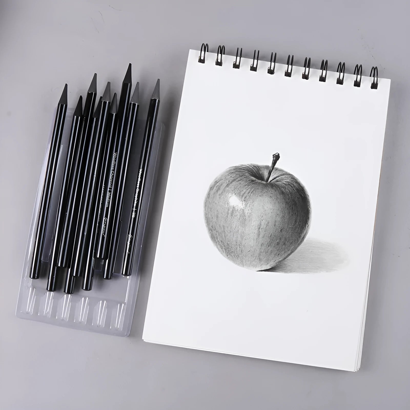 Set of nine wooden drawing pencils on a card, including graphite and carbonized pencils for sketching.