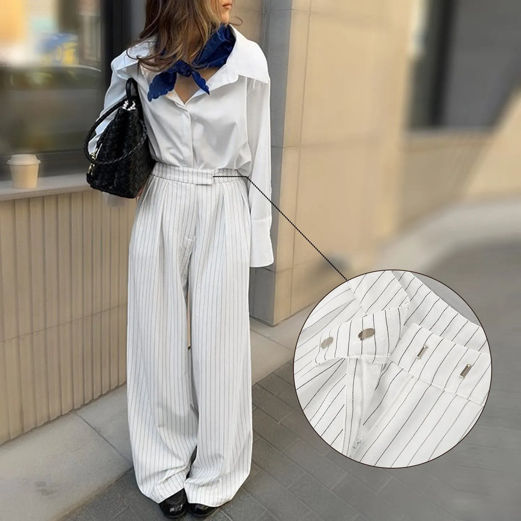 White striped wide-leg women's trousers with a front zipper on a hanger.