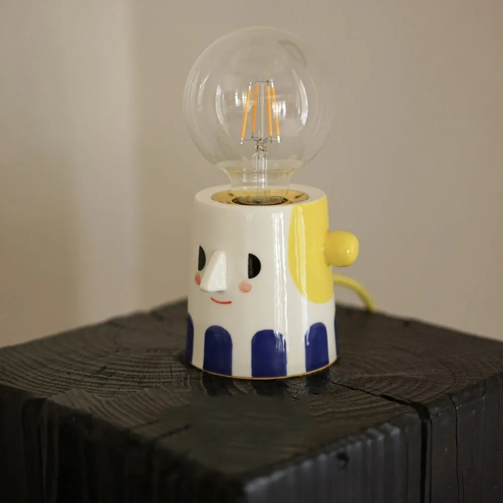 Handmade white ceramic bedside lamp with ball headlight design on wooden table