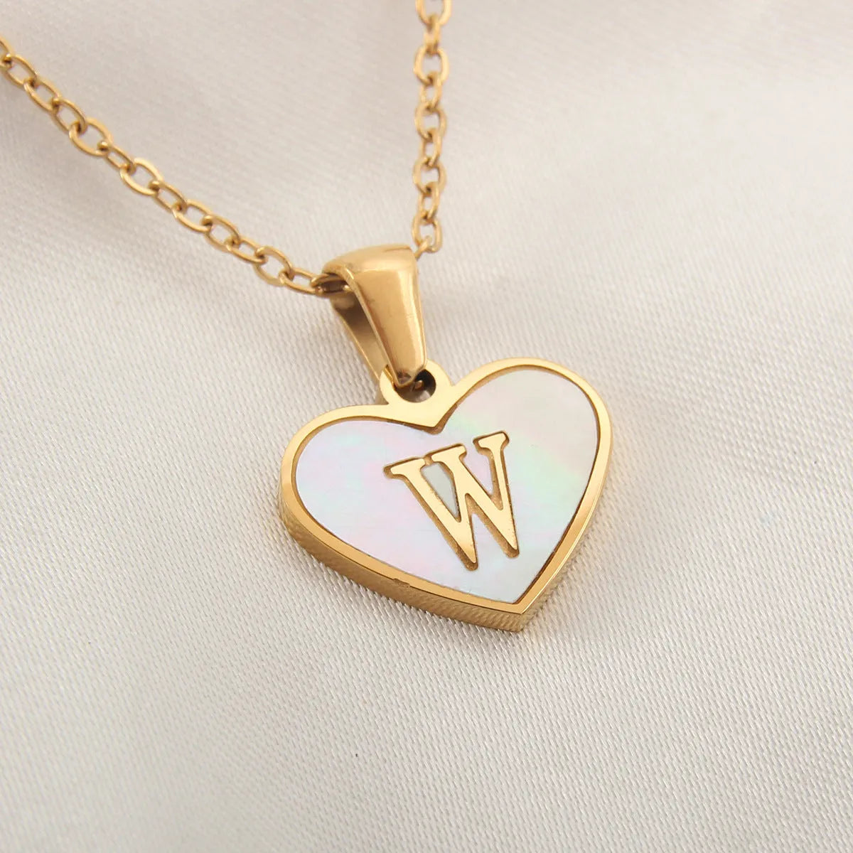 Gold plated heart-shaped necklace with white shell pendant on adjustable stainless steel chain