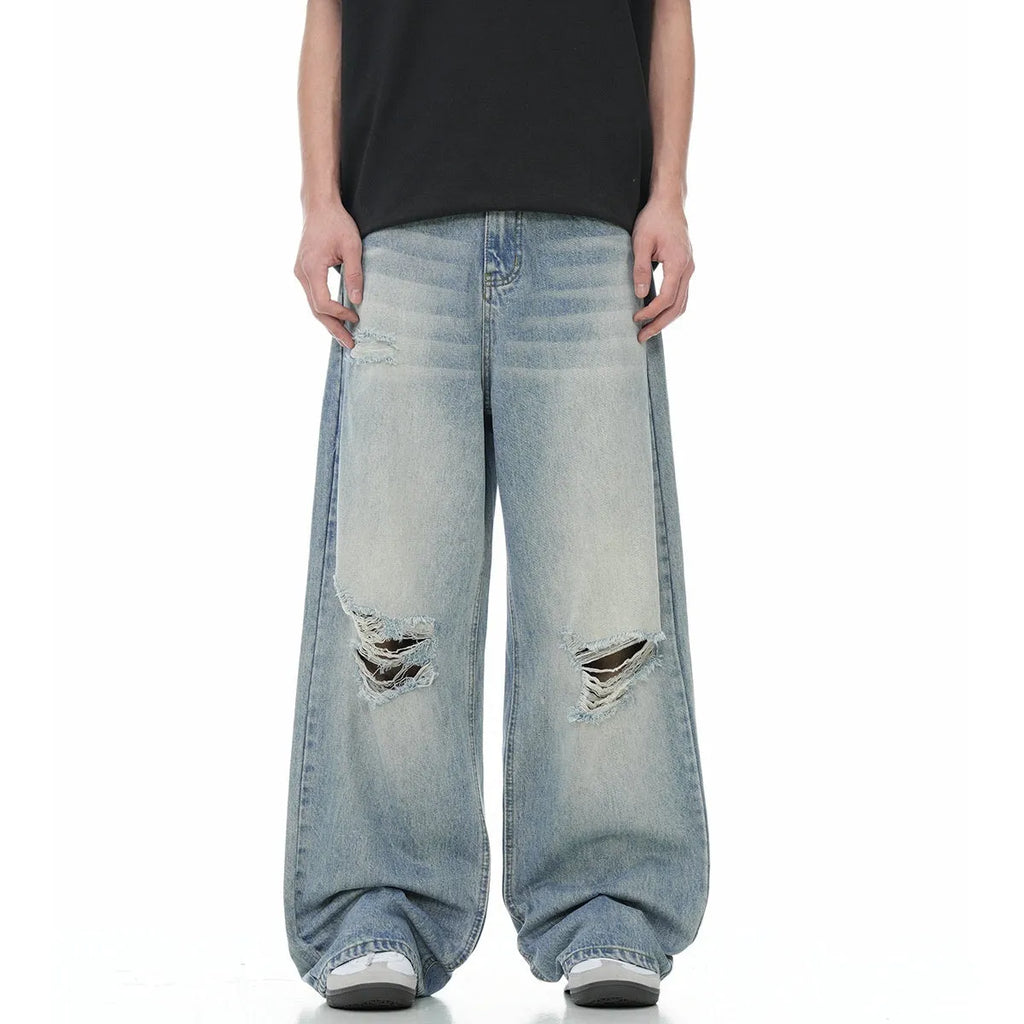 Blue men's straight-leg jeans with ripped detailing on the legs, showing a zipper fly.