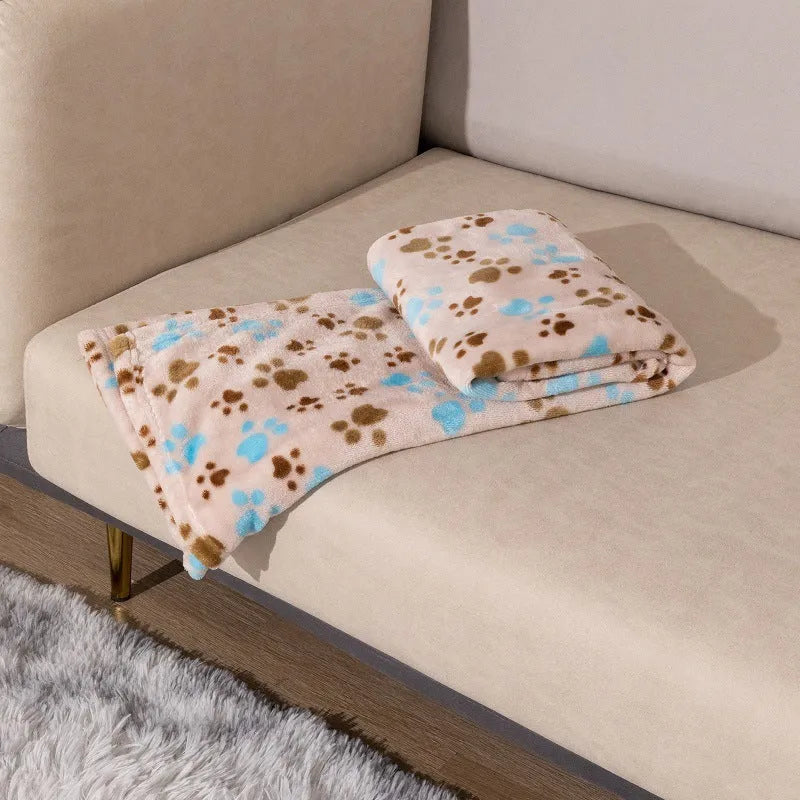 Blue cartoon dog paw patterned flannel pet blanket laid flat, showing its size.
