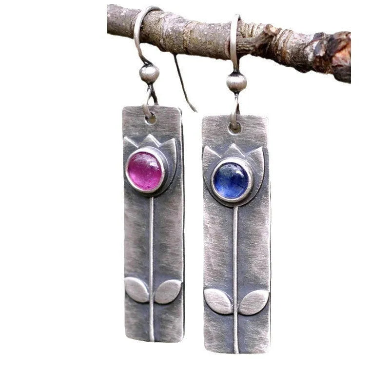 A pair of red sapphire earrings with an antique finish and geometric design.