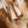 Champagne coloured bridal shoes with pointed toe, fine heel, and rhinestone floral decoration.
