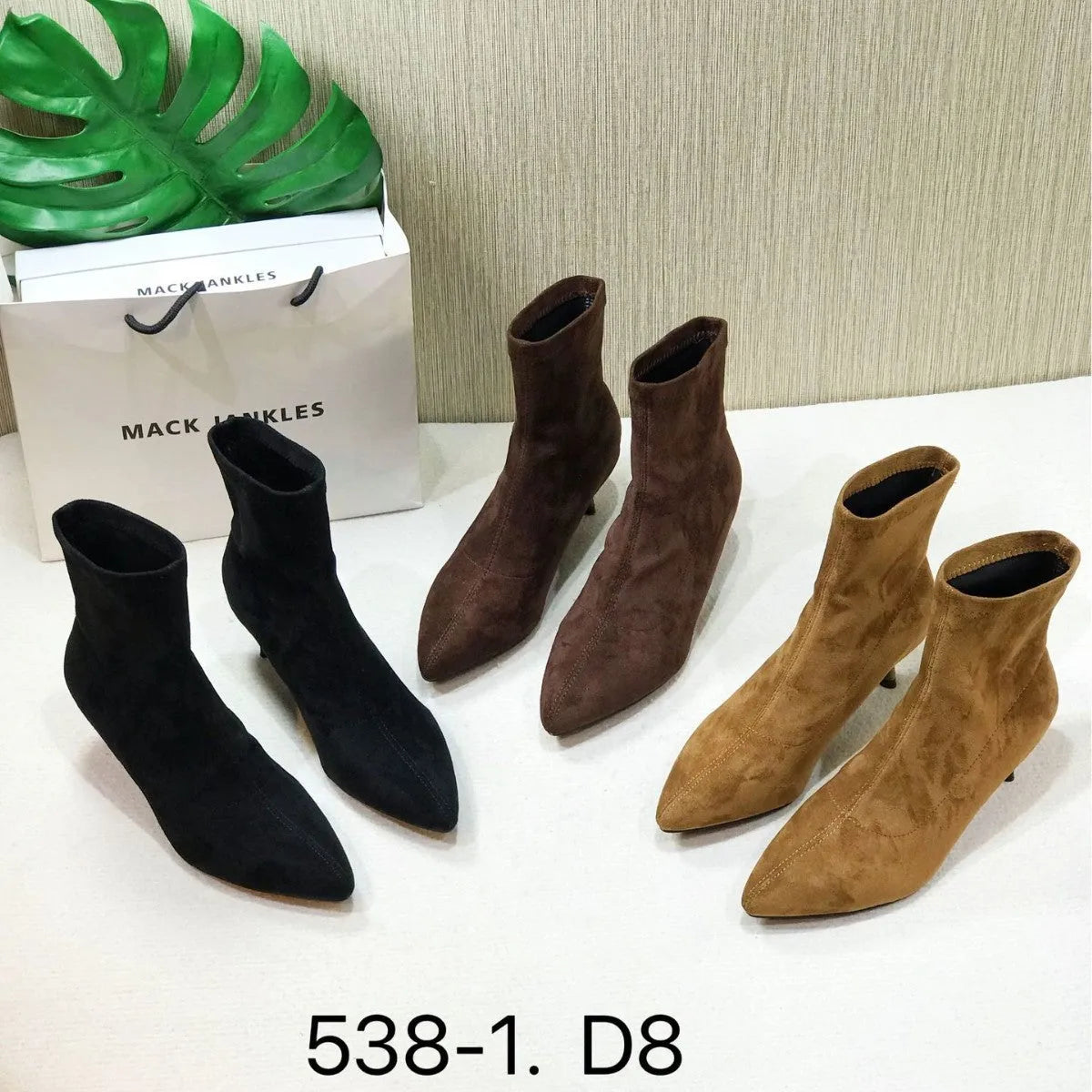 Black pointed toe women's ankle boots with a stiletto heel on a neutral background.