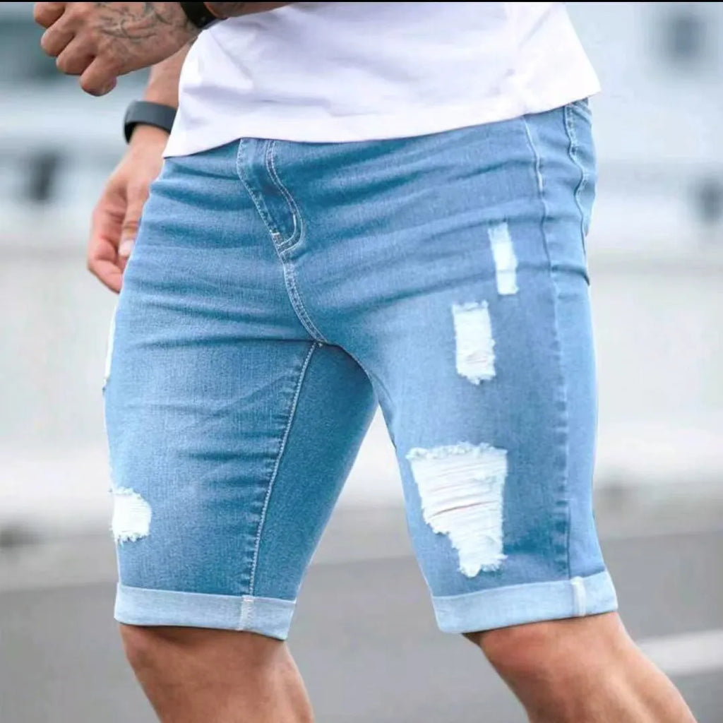 Sky blue men's denim shorts with a multi-hole distressed design and a straight leg.
