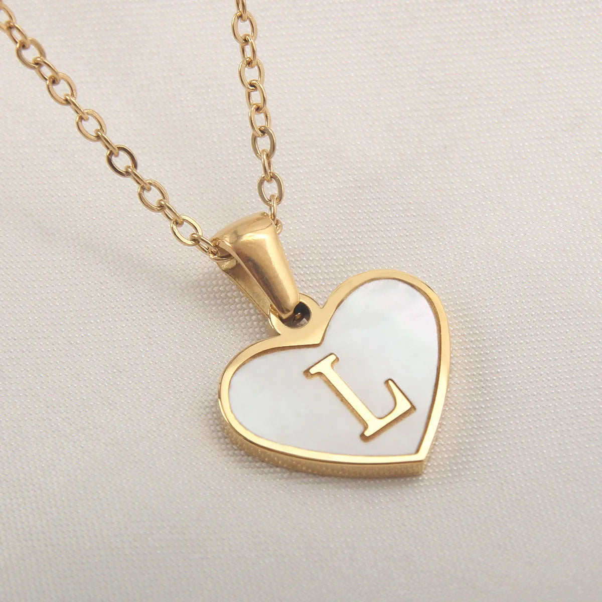 Gold plated heart-shaped necklace with white shell pendant on adjustable stainless steel chain