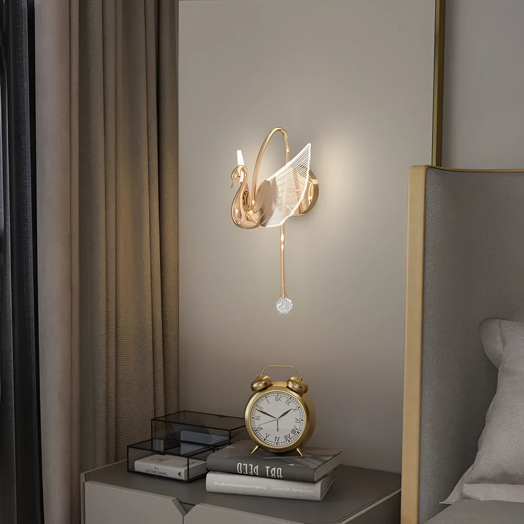 Gold minimalist swan wall lamp with acrylic shade mounted beside bed
