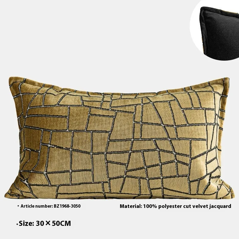 Geometric abstract pattern decorative pillow case in gold colour on a grey sofa.