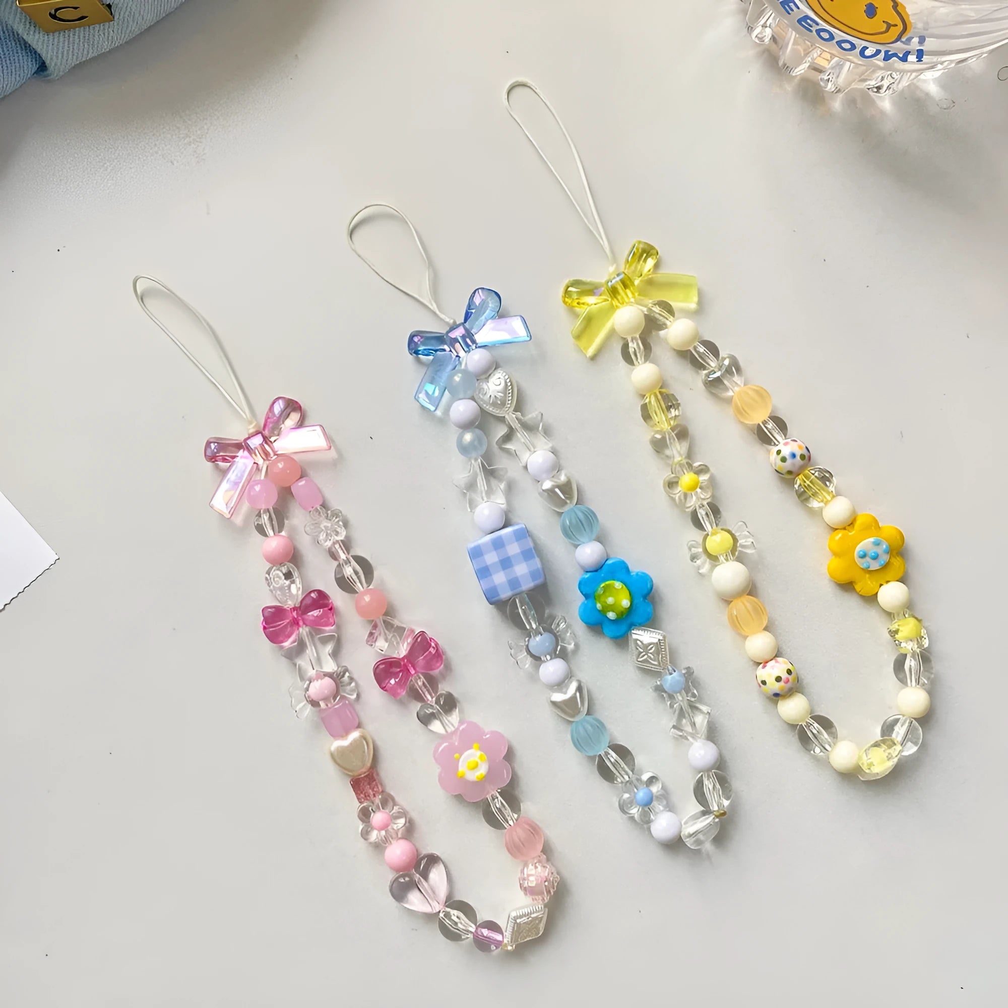Beaded flower mobile phone lanyard with plastic resin floral decorations in yellow, blue, or pink colours