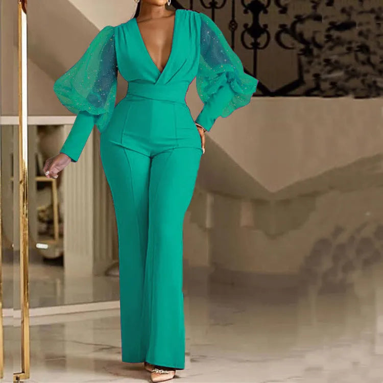Red women's long sleeve jumpsuit with mesh stitching detail, elastic waist, and wide leg trousers.