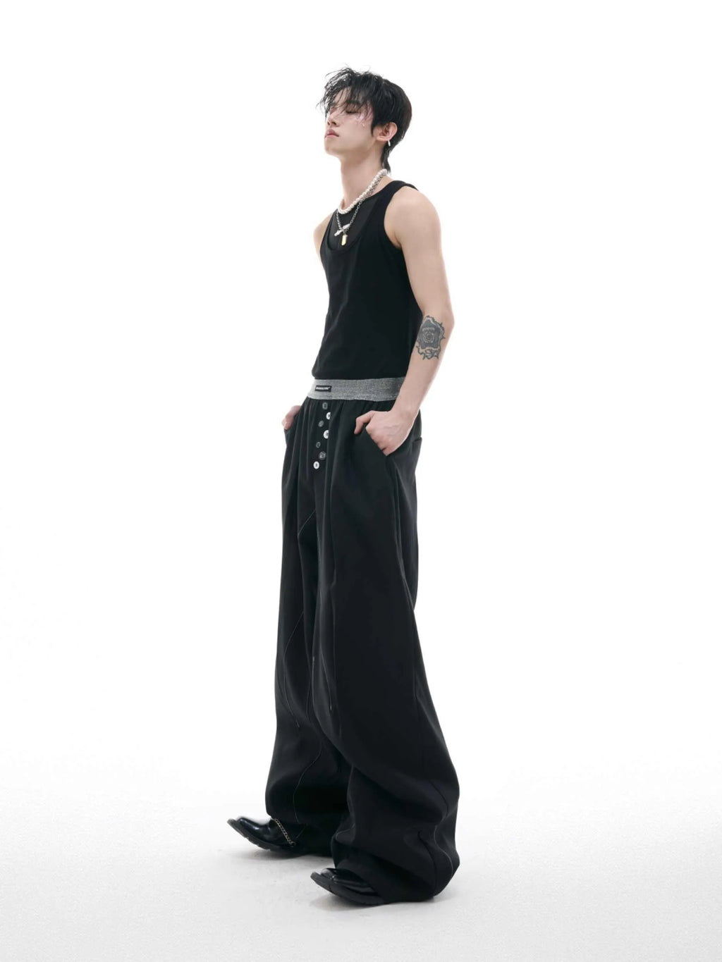 Men's grey straight-leg high-waisted trousers with a button-fly opening on a neutral background.