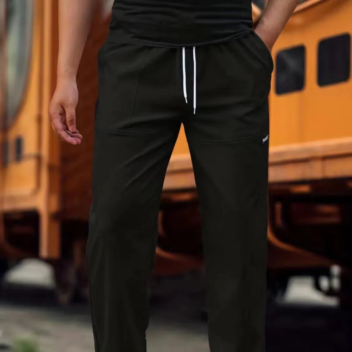 Men's straight-leg lightweight polyester trousers in light grey colour, laid flat showing front design