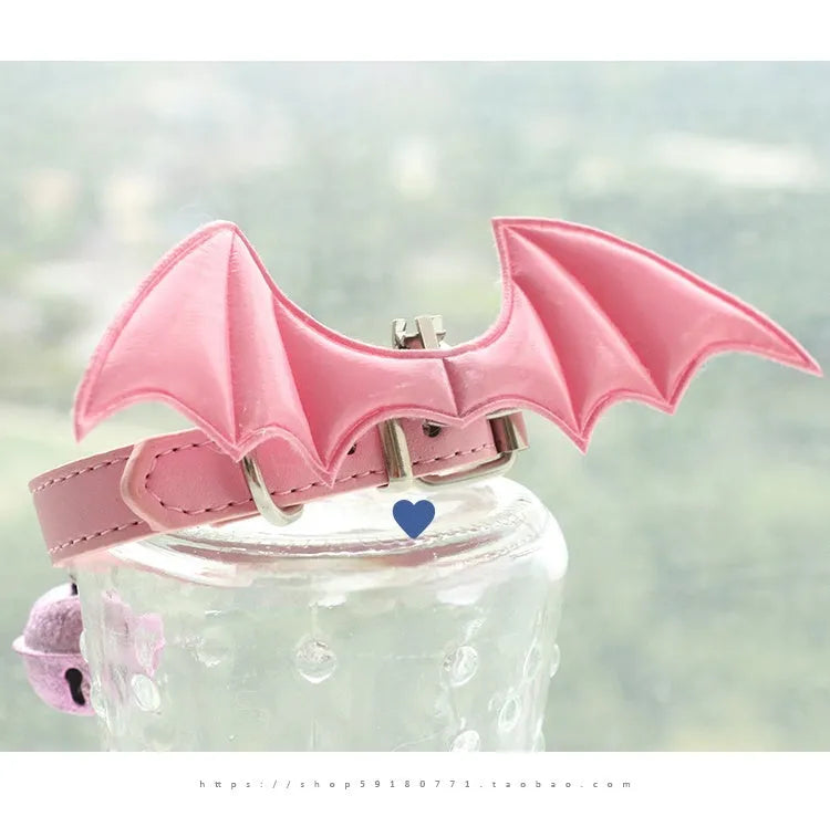 Black patent leather dog collar for small dogs with decorative wings and a bell