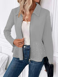 Women's loose black coat with beaded zipper and ruffled hem, shown on a hanger.