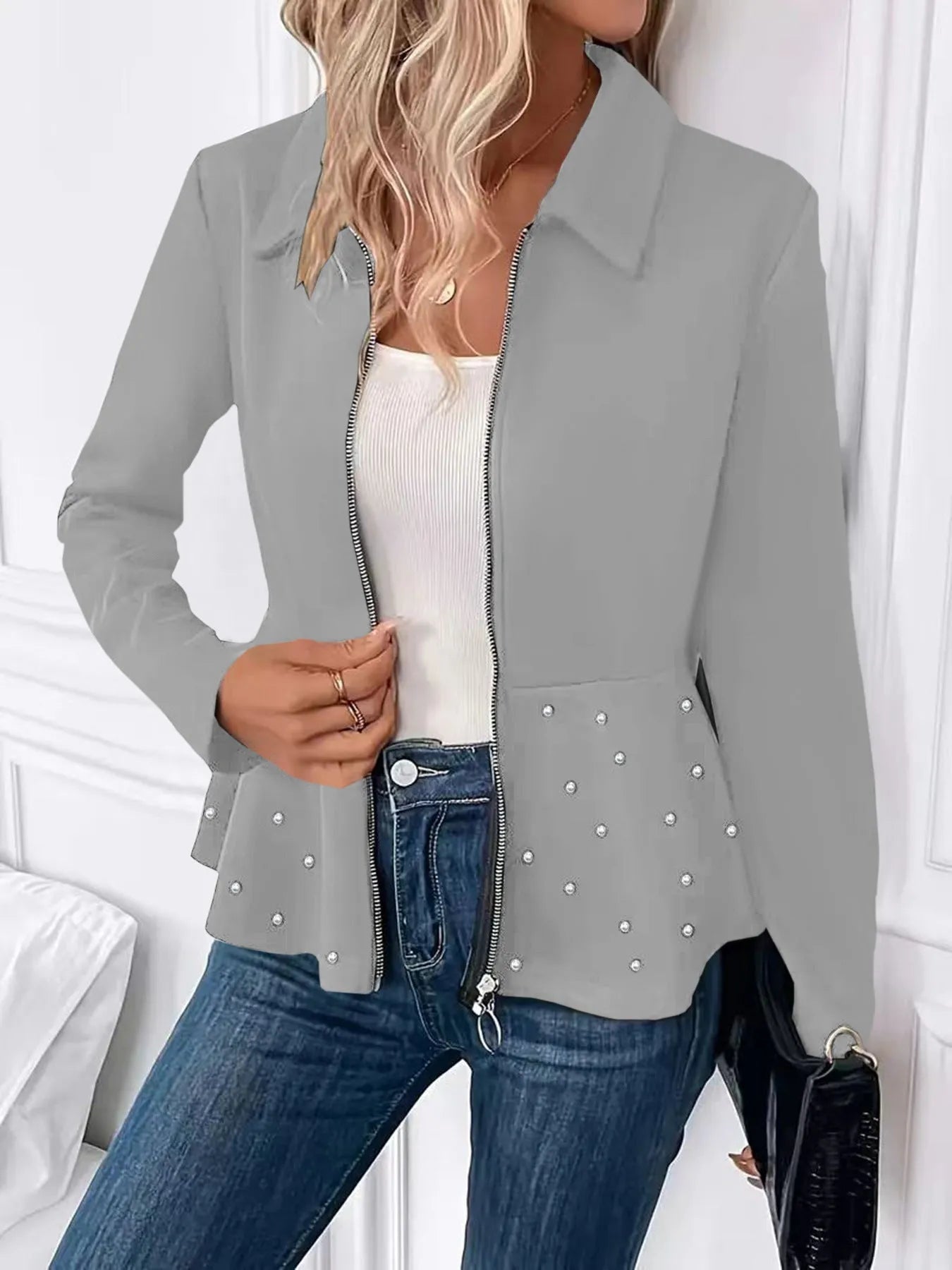 Women's loose black coat with beaded zipper and ruffled hem, shown on a hanger.