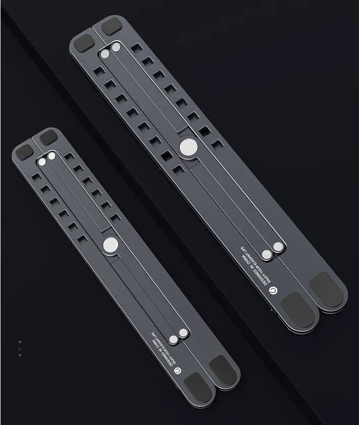 Silver foldable aluminium laptop stand holding a MacBook at an angle, shown next to a backpack.