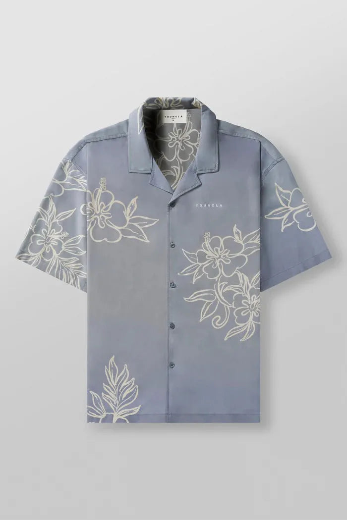 Man wearing a loose-fit, short sleeve floral print top in a neutral colour.