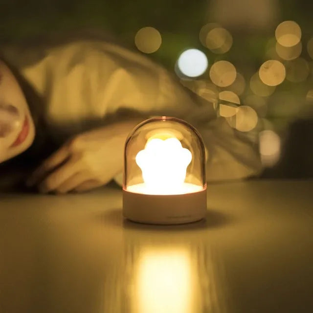 Grey cat paw shaped USB rechargeable night light and music box with soft glowing light.