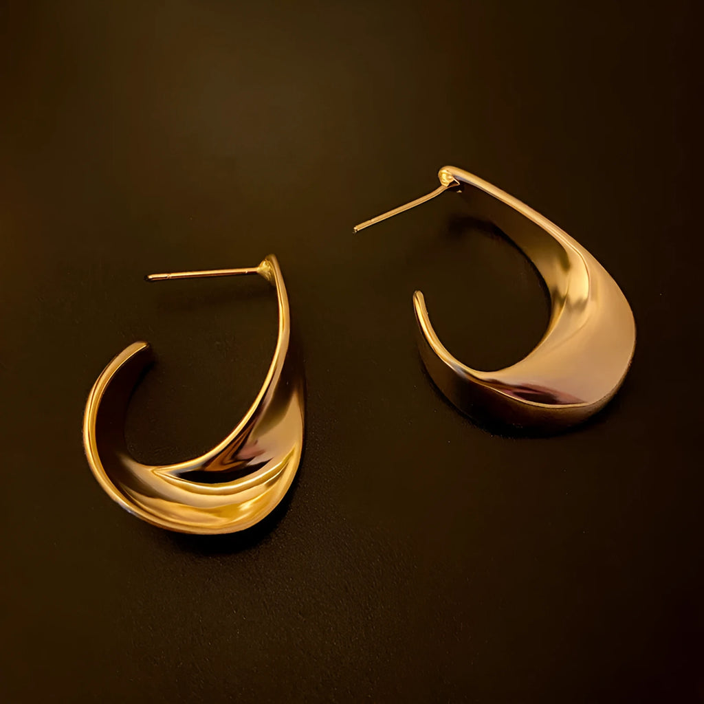 Gold and silver twisted geometric metal earrings with round shape and electroplated finish
