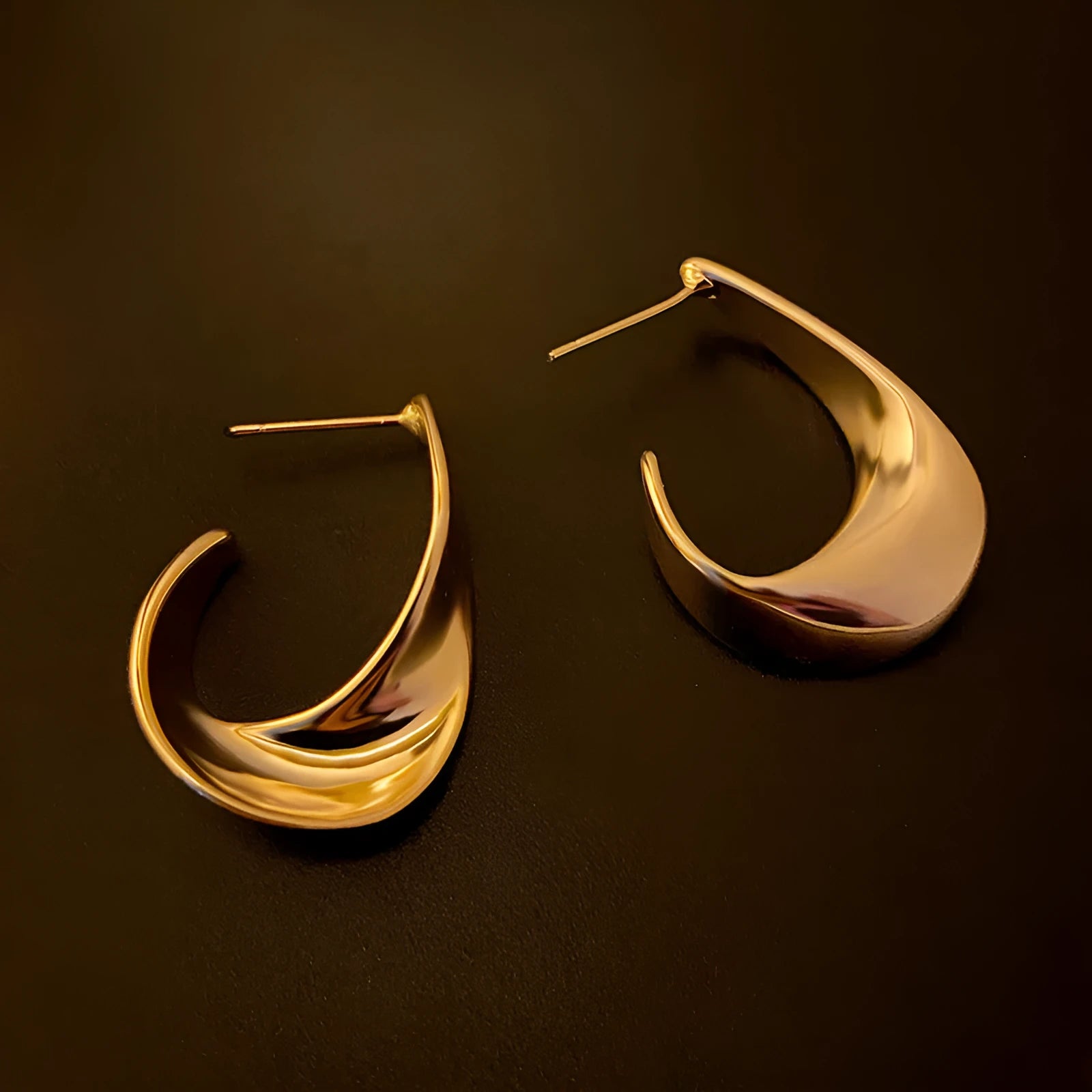 Gold and silver twisted geometric metal earrings with round shape and electroplated finish