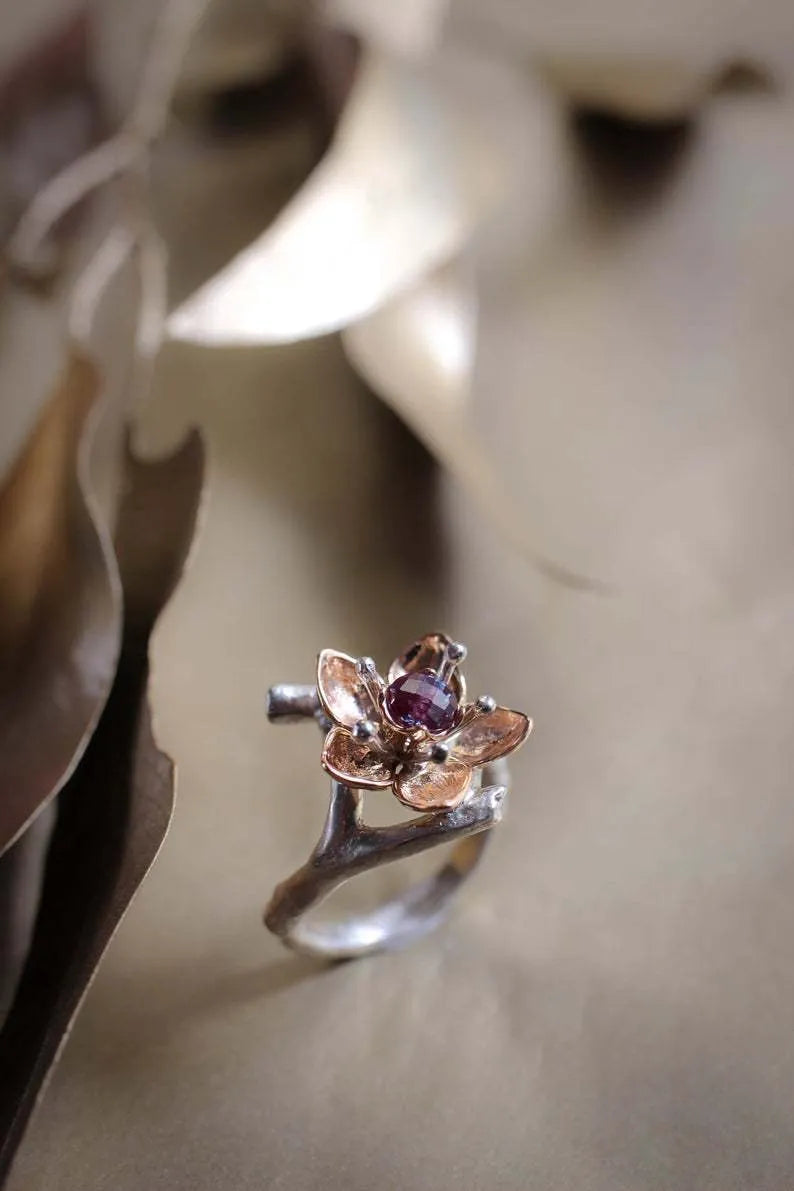 Silver-tone alloy women's ring with geometric shape and two-tone floral design on a white background.