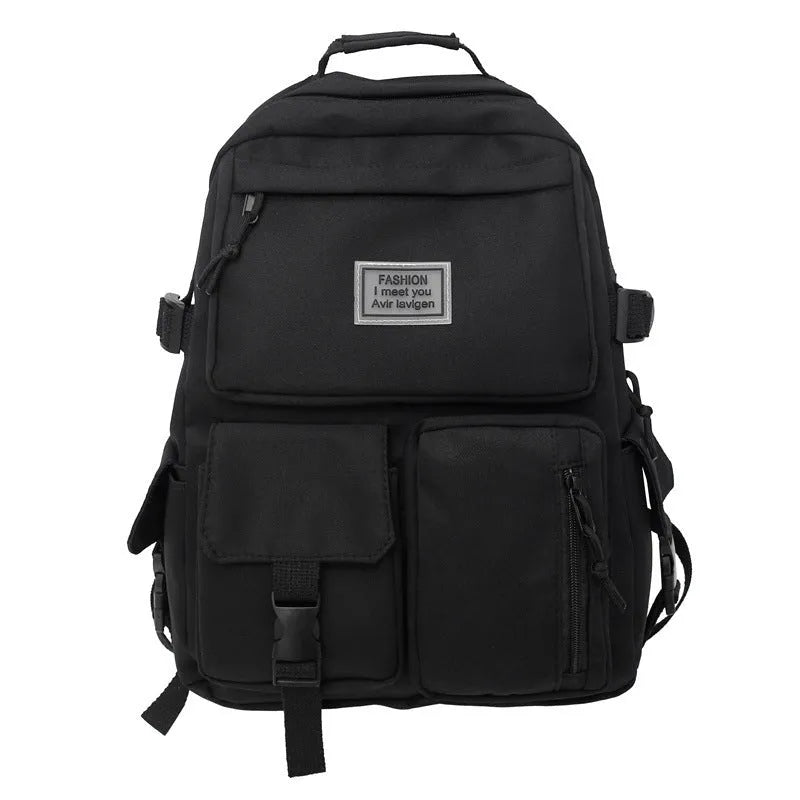 Black and white nylon student backpack with front 3D pockets, shown with laptop in compartment.