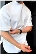 Man wearing a white men's t-shirt with a round bottom hem and a single button closure on the chest.