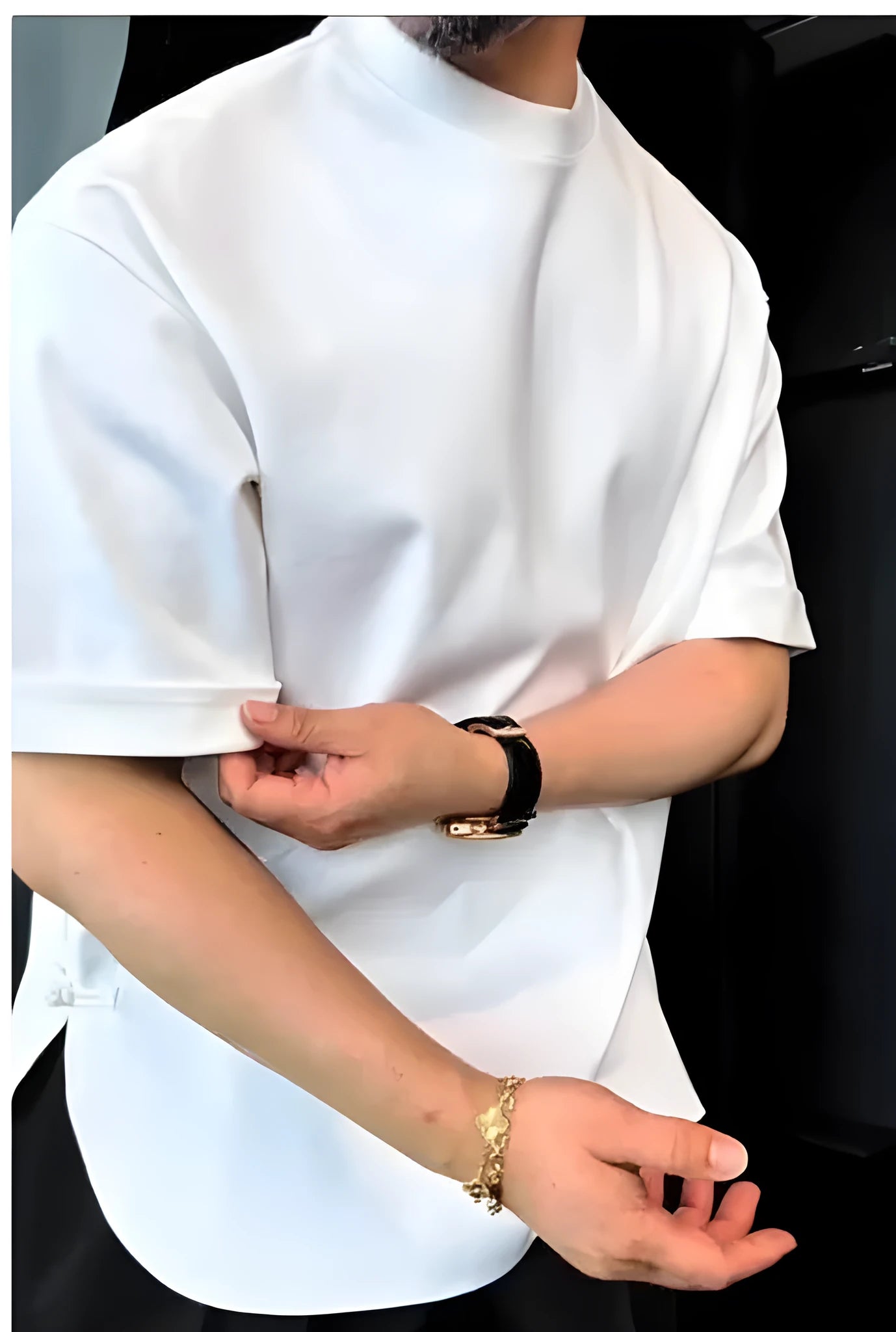 Man wearing a white men's t-shirt with a round bottom hem and a single button closure on the chest.