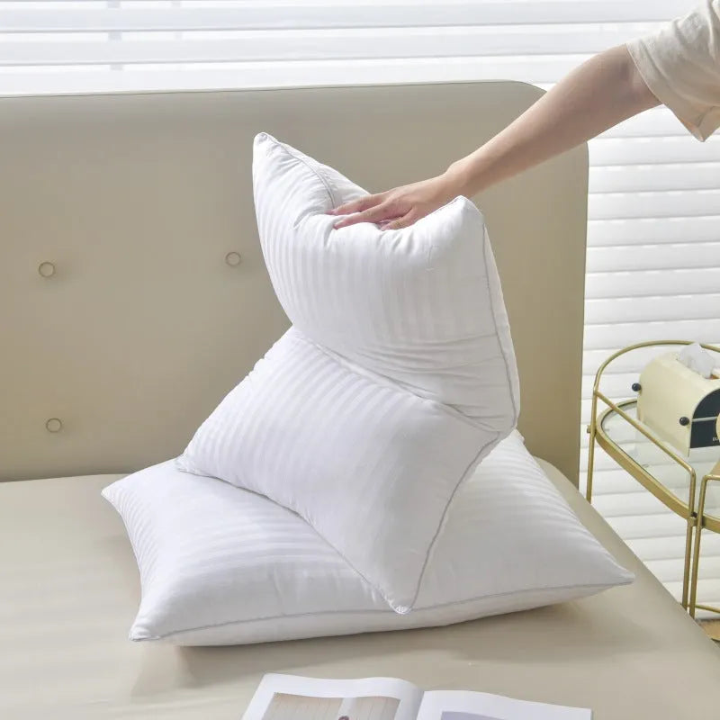 White hotel cotton satin stripe pillow with feather and cotton filling on a bed.
