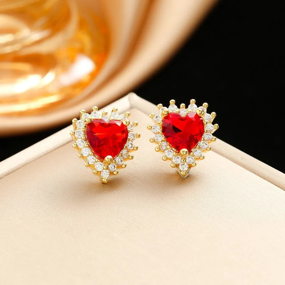 Women's heart-shaped jewellery set with matching necklace, stud earrings, and ring in electroplated gold red finish