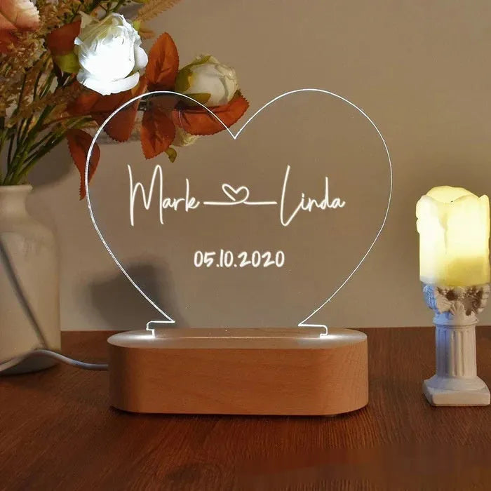 Custom transparent acrylic night light engraved with names, lit by LED base, dimensions 20cm by 11.5cm.