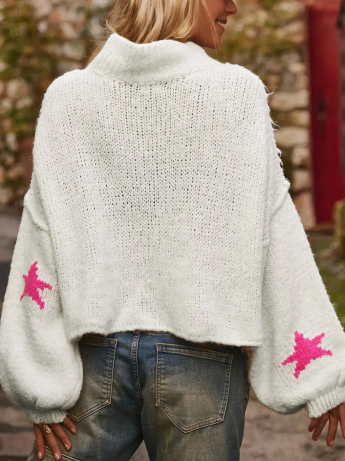 White women's loose turtleneck pullover with a black five-pointed star pattern on the front, made from thick polyester fabric.