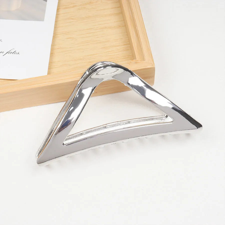 Silver metal hair claw clip assortment showing bows, waves, pearl designs, and geometric shapes from 4cm to 13.5cm