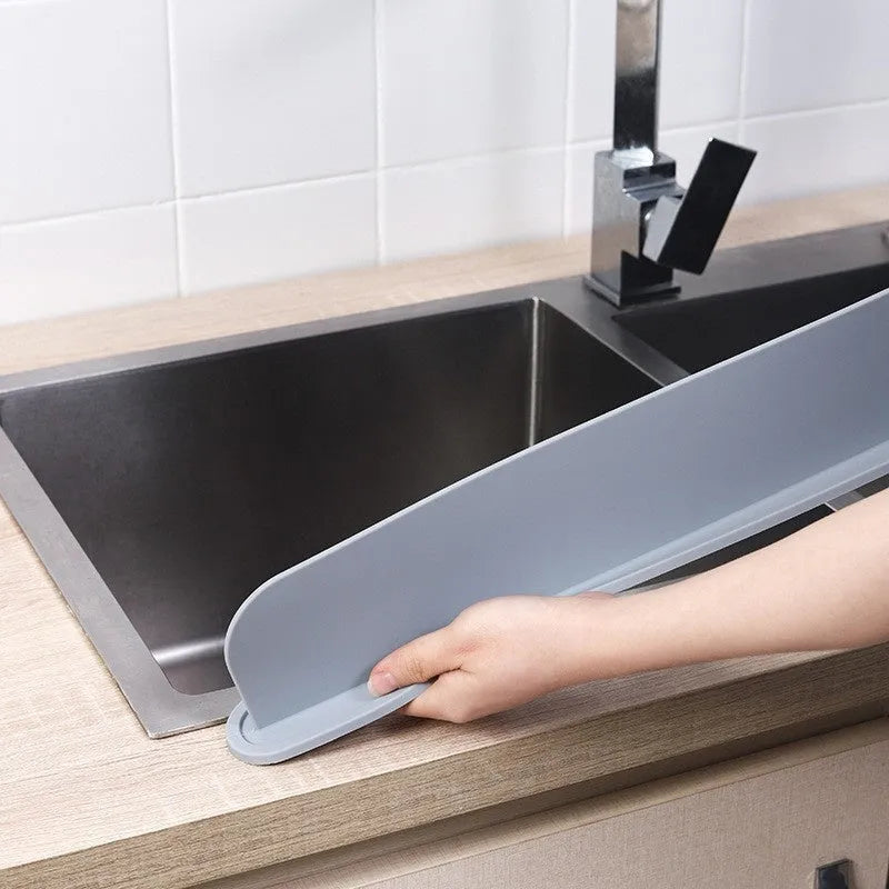 Thick grey silicone sink splash guard fitted on a kitchen sink edge