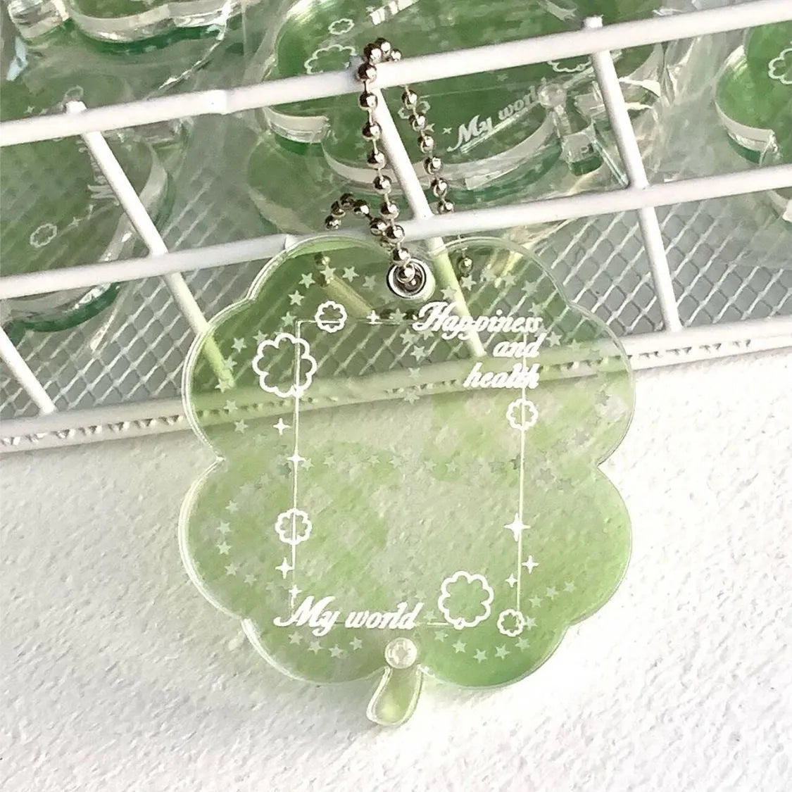 Acrylic four-leaf clover pendant charm for phone or keychain in blue or green colours.