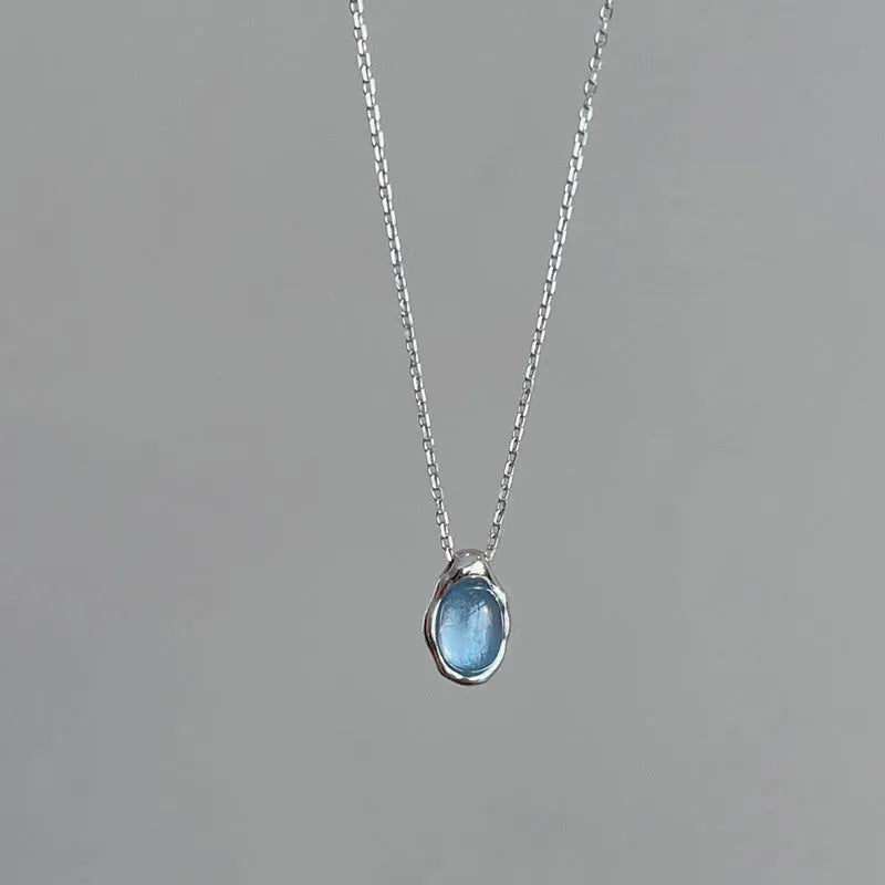 Navy blue geometric water drop pendant necklace on model showing adjustable cross chain design