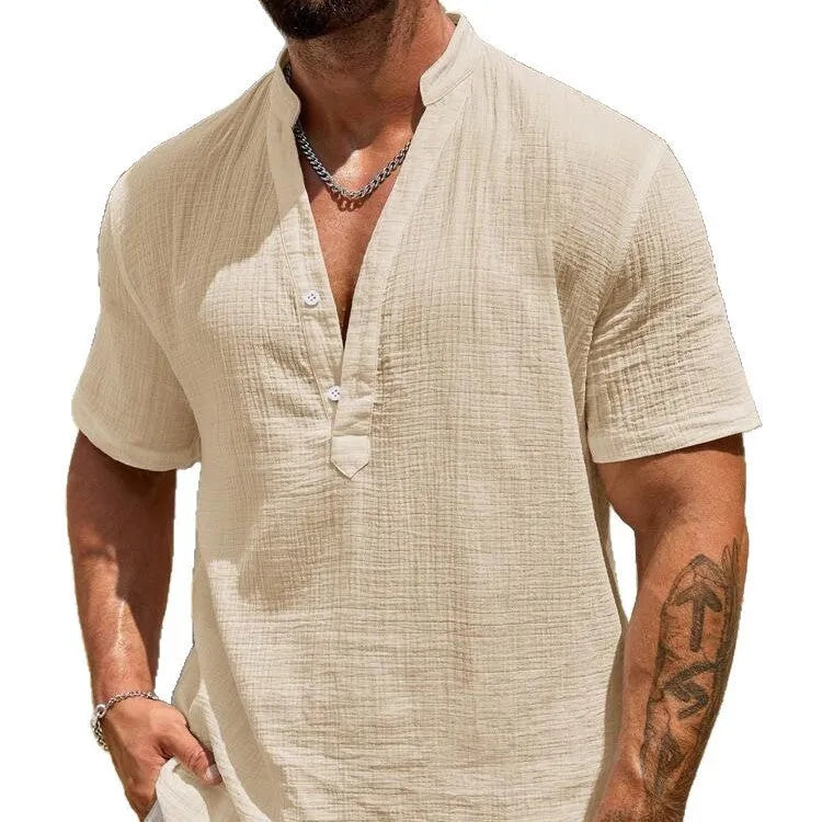 Man wearing a solid colour short-sleeve shirt with a stand collar in a casual setting.