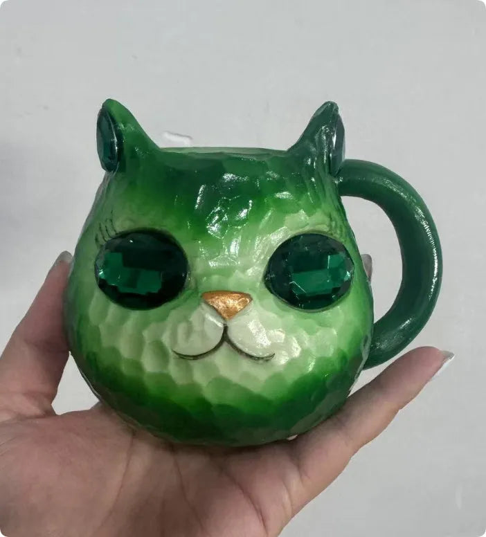 Coloured resin cat cup decoration in purple, green, blue, or pink on a shelf.