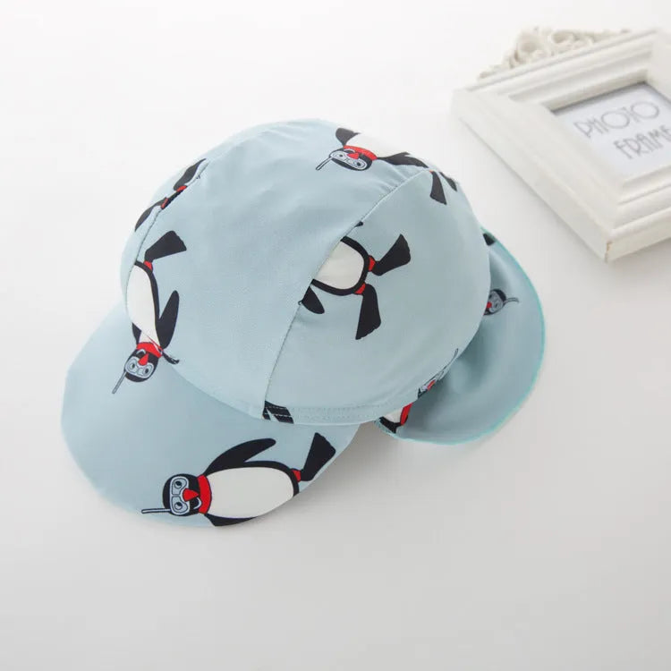 Blue boys two-piece penguin swimsuit with long sleeves and a matching swim cap.