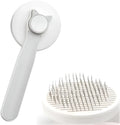 Self-cleaning cat brush with blue rubber handle and metal pins with rubber tips for pet grooming