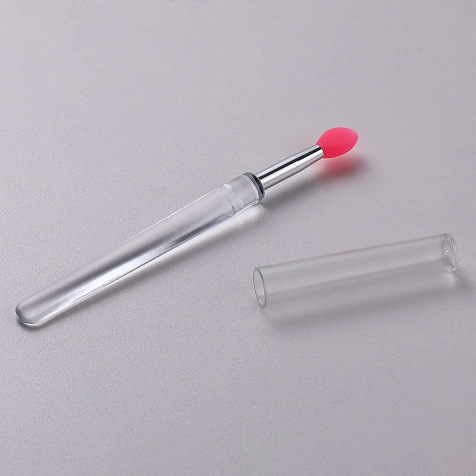 A reusable silicone lip brush with a handle and protective cap, shown in one of eight available colours.